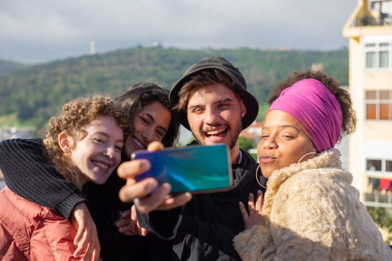 Group of friends taking a selfie together outdoors for a photo dump post